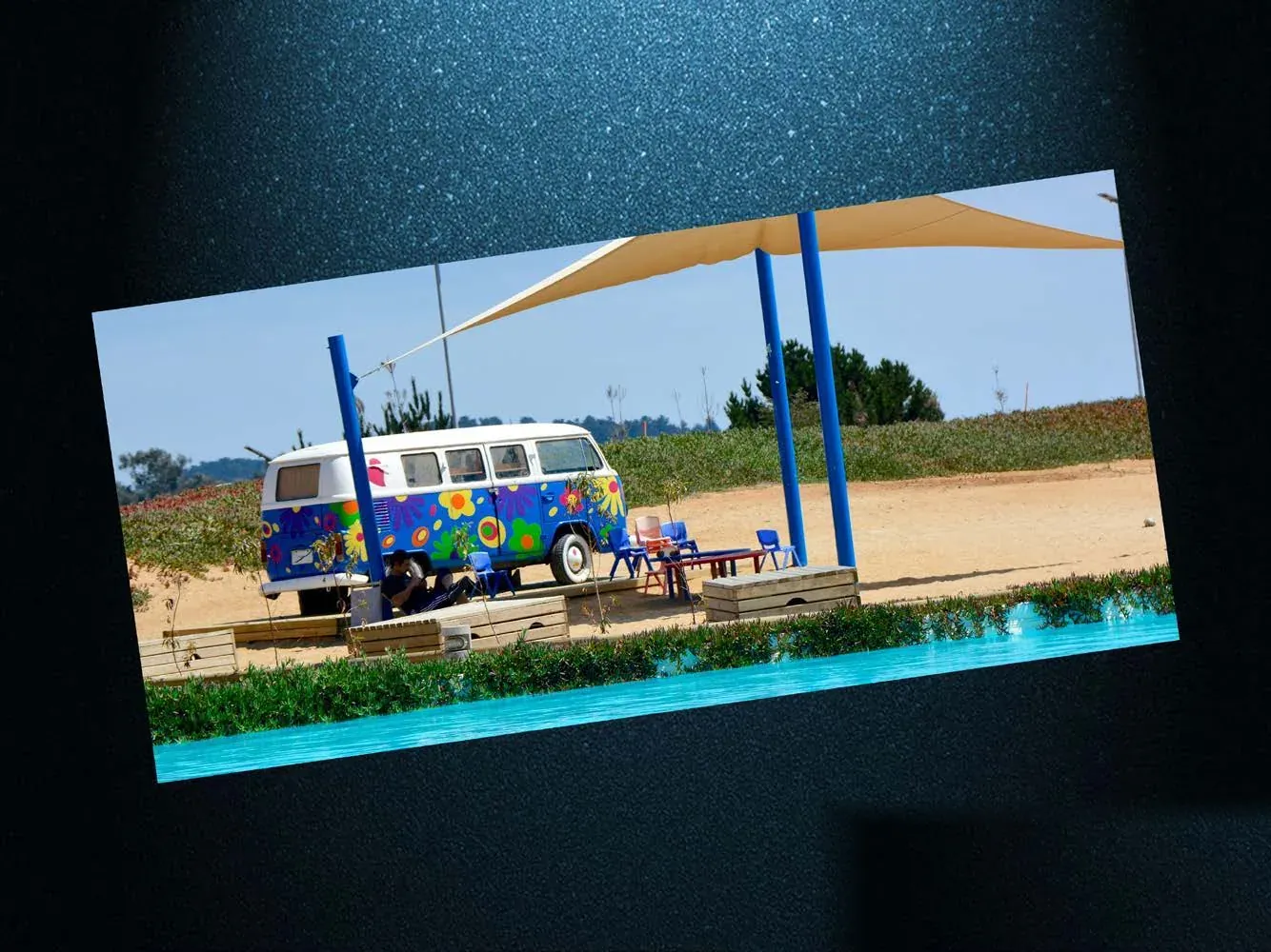 Combi Volkswagen ploteada como librería junto a una laguna, para Laguna Bahía.